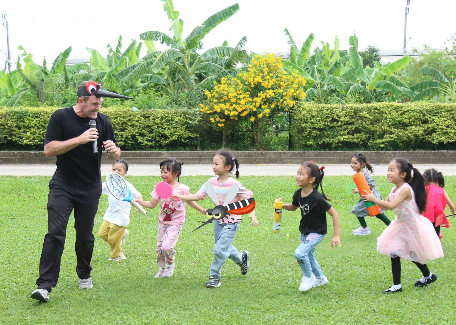 Native English-speaking teacher playing with Kindergarten students outdoors at Ek Burapa School — Oxford International Curriculum EP school from K.1, Minburi Bangkok