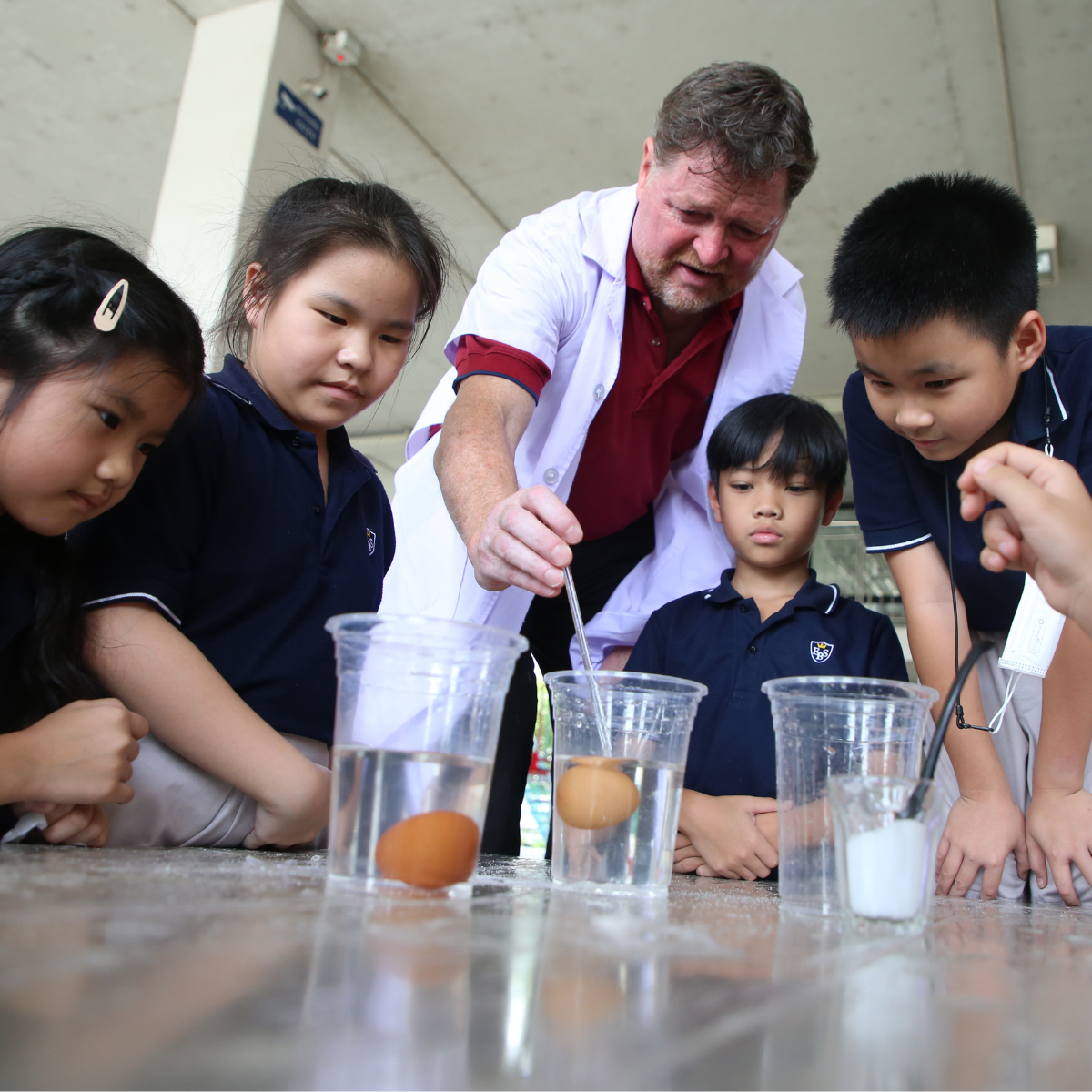 : Native English teacher guiding science experiment at Ek Burapa School — critical thinking inquiry-based OIC EP school Bangkok